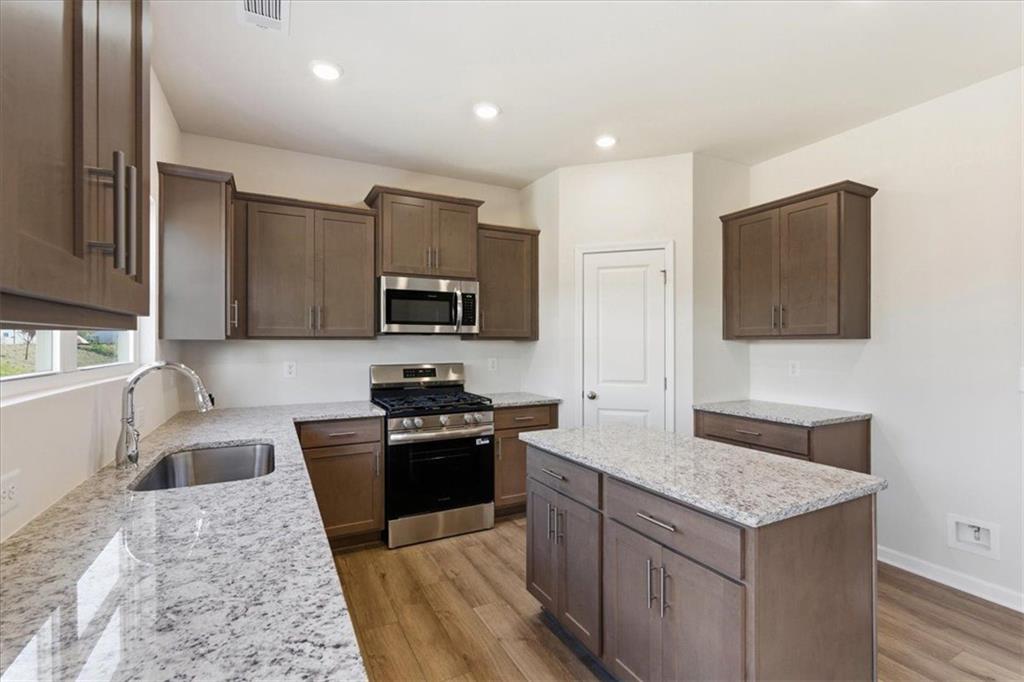 129 Bloomfield Circle Canton, GA 30114 - Photo 12 of 36 a kitchen with granite countertop a stove top oven microwave and refrigerator
