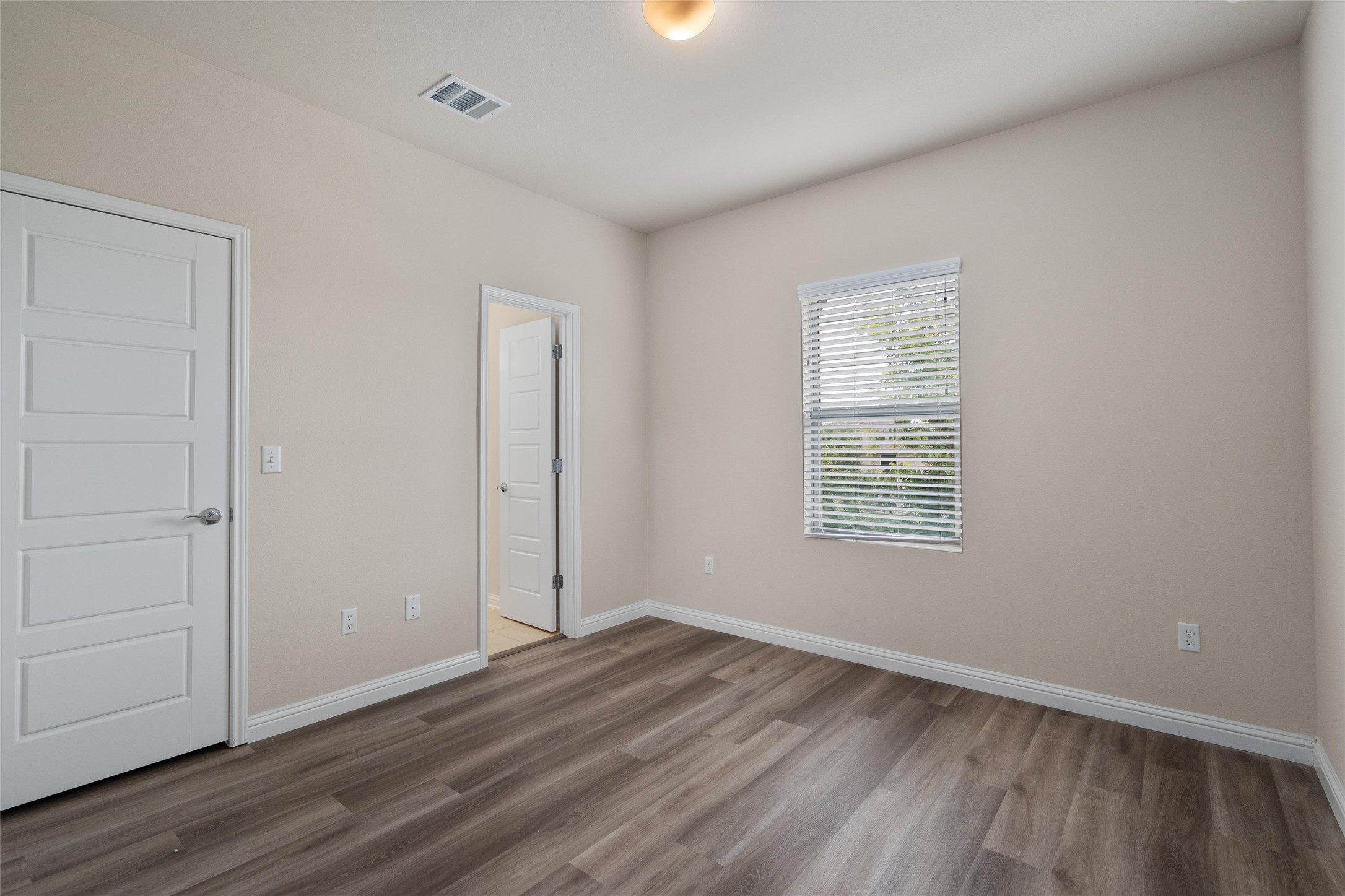 6907 Idea Road Austin, TX 78741 - Photo 19 of 36 an empty room with wooden floor and windows