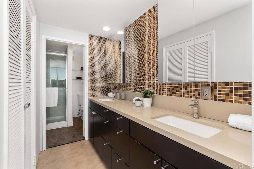 2500 Torrey Pines Road, Unit 402 La Jolla, CA 92037 - Photo 23 of 50 a bathroom with a double vanity sink and mirror
