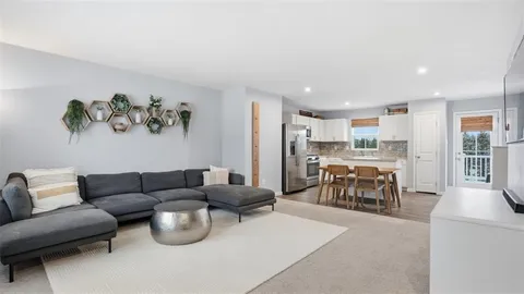 a living room with furniture and a kitchen view