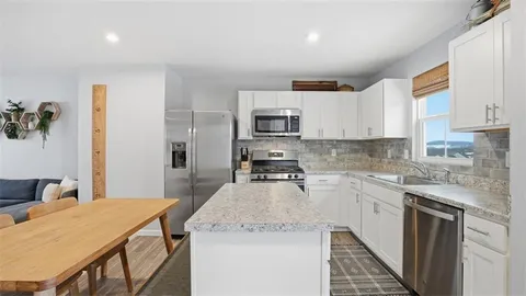 a kitchen with a stove a sink a microwave a refrigerator and cabinets