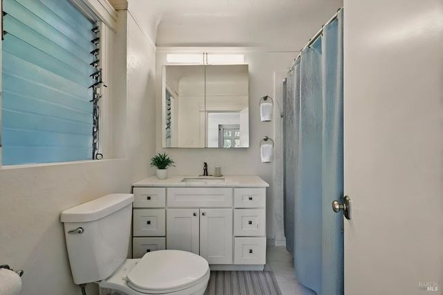 a bathroom with a toilet a sink a vanity and mirror