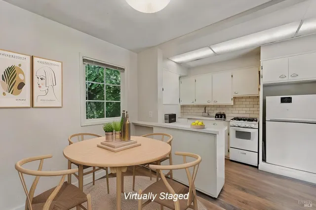 a kitchen with stainless steel appliances a dining table and chairs