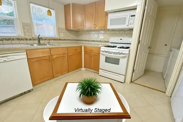 a kitchen with stainless steel appliances granite countertop a sink a stove and cabinets