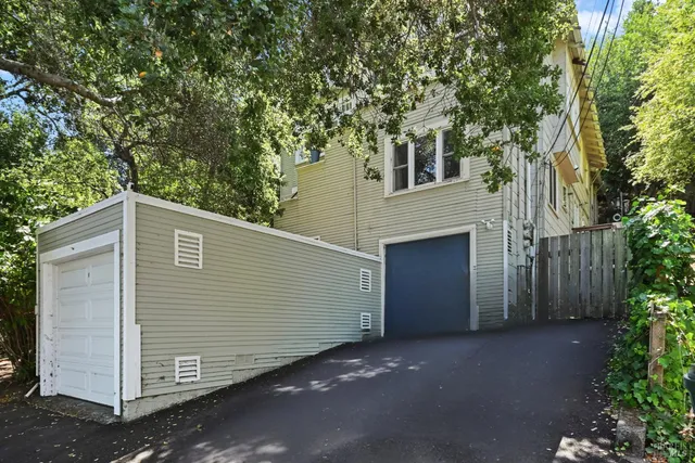 a front view of a house with a tree