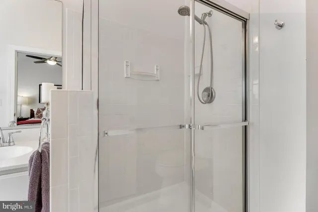 a spacious bathroom with a sink a toilet a mirror and shower