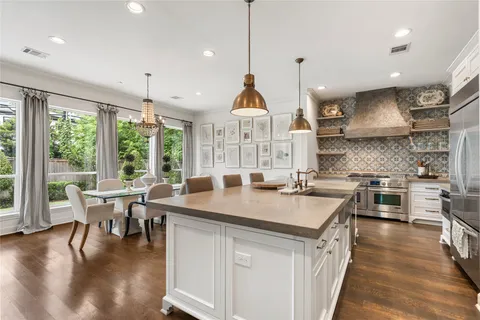 a kitchen with stainless steel appliances granite countertop a stove a kitchen island a stove and a wooden floors