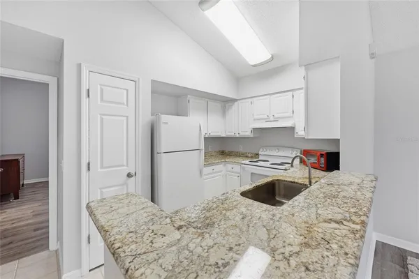 a kitchen with a refrigerator sink and cabinets