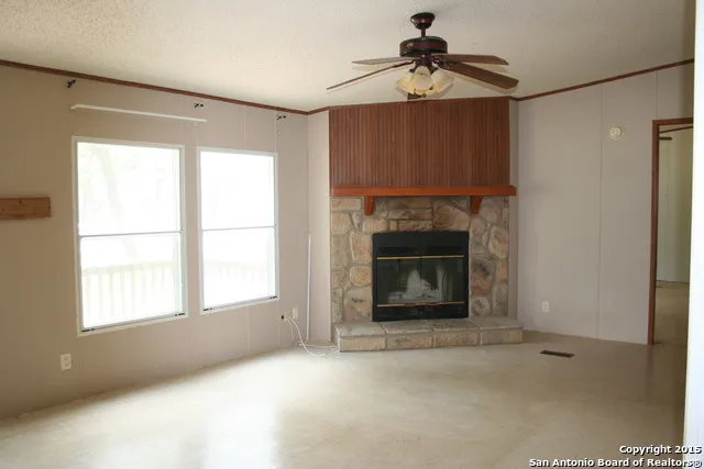 a view of empty room with fireplace and fan
