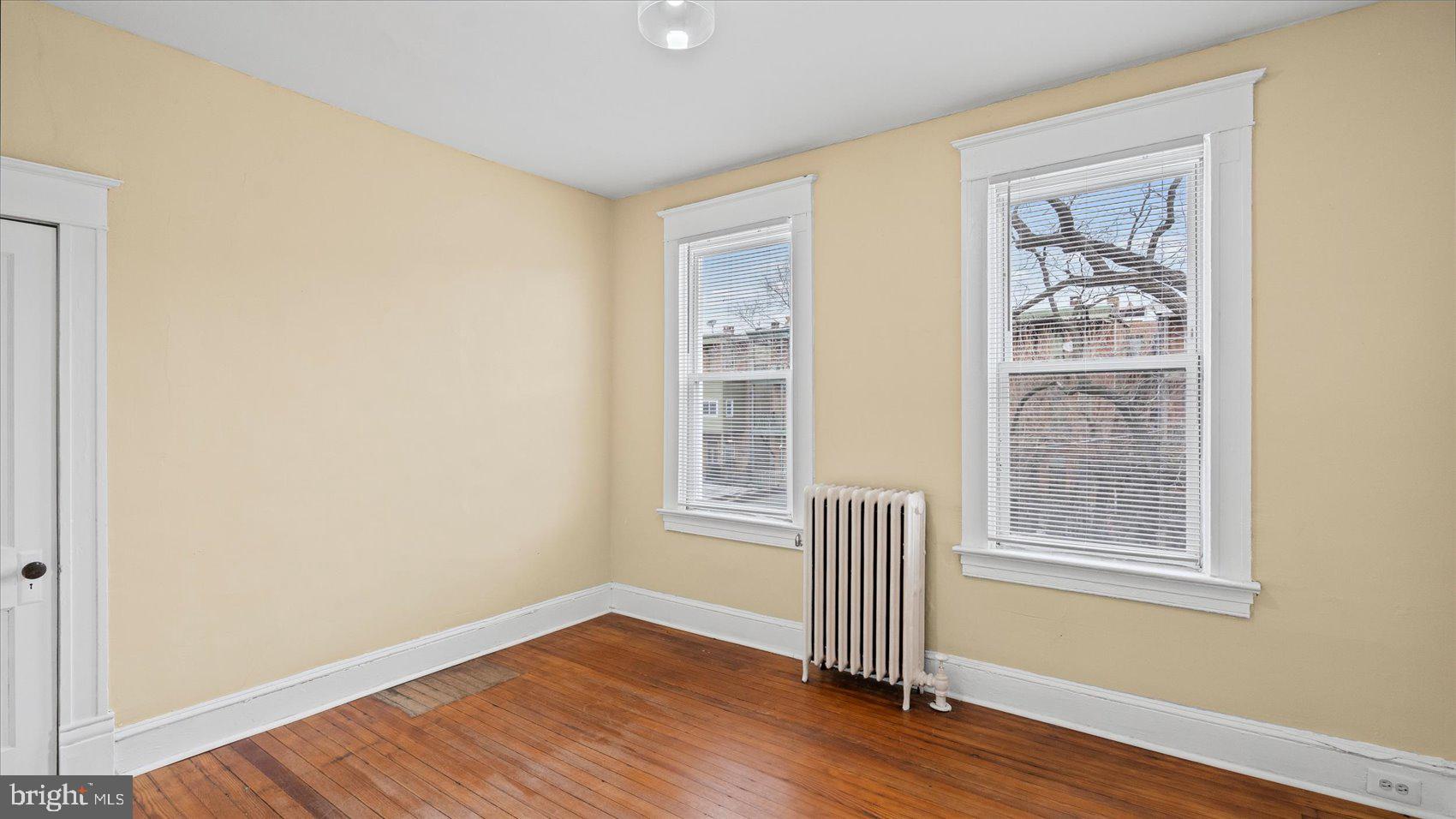 2413 Madison Avenue Baltimore, MD 21217 - Photo 19 of 48 a view of an empty room with wooden floor and a window