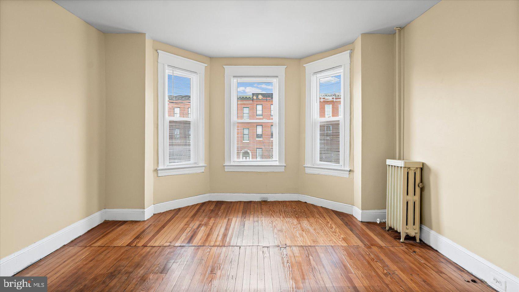 2413 Madison Avenue Baltimore, MD 21217 - Photo 21 of 48 an empty room with wooden floor and windows