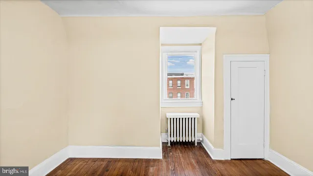 a view of a room with wooden floor and a window