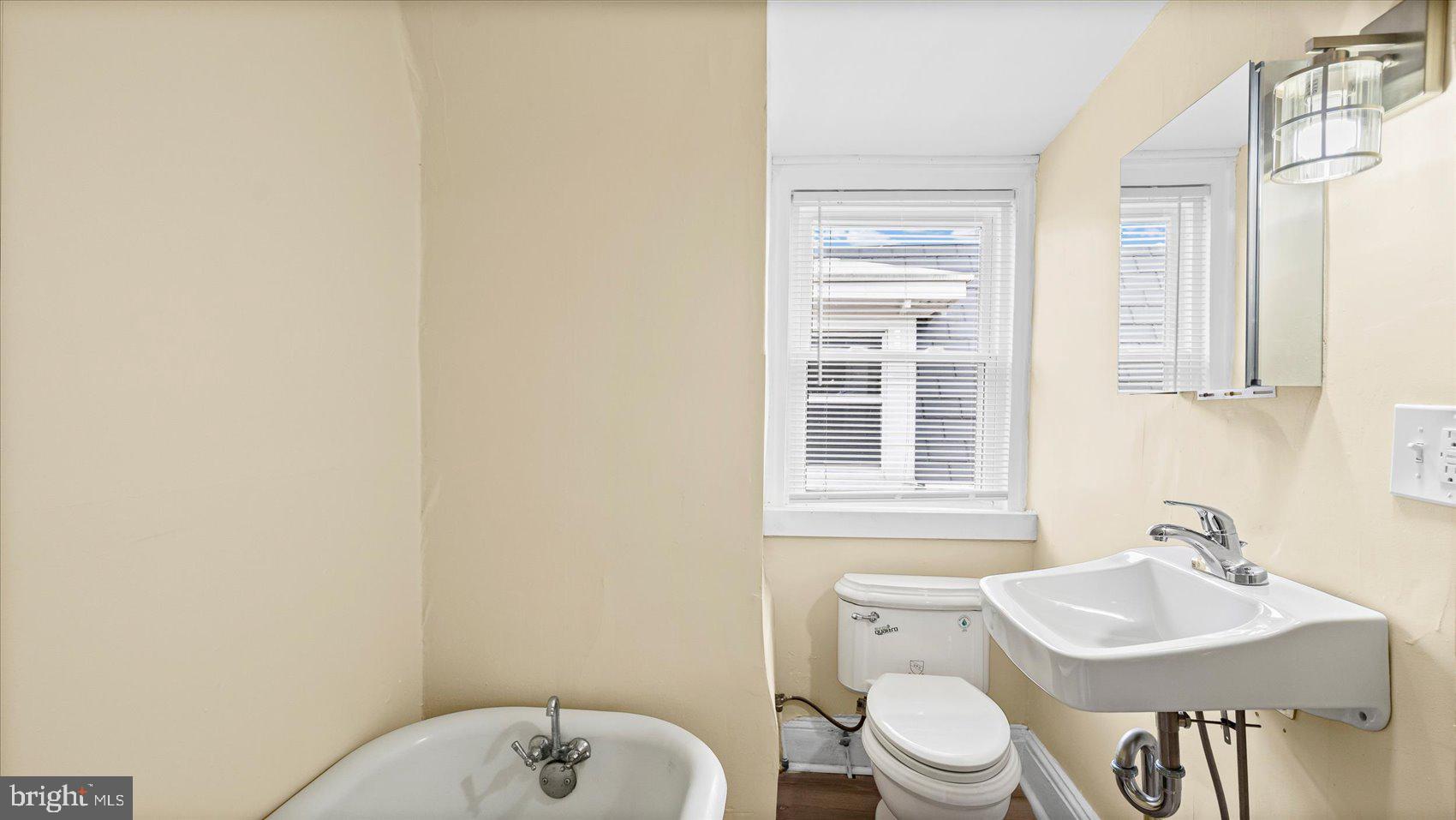 2413 Madison Avenue Baltimore, MD 21217 - Photo 33 of 48 a bathroom with a sink a toilet and a mirror