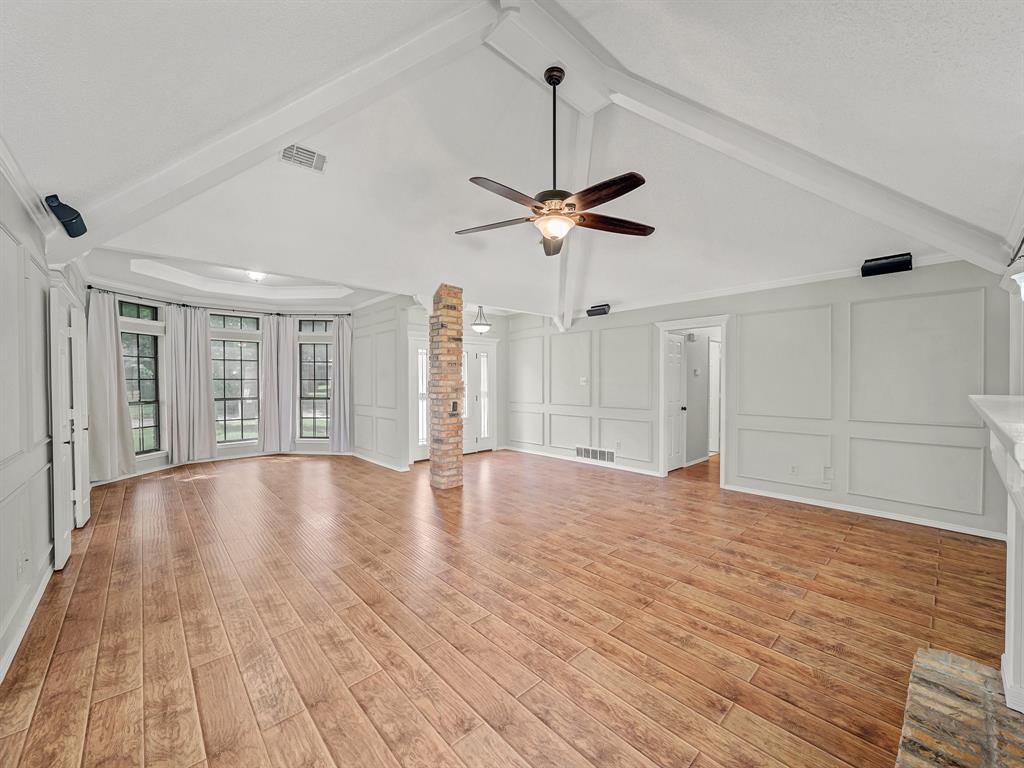 121 Northeast Brushy Mound Road Burleson, TX 76028 - Photo 8 of 35 a view of an empty room with wooden floor and a ceiling fan