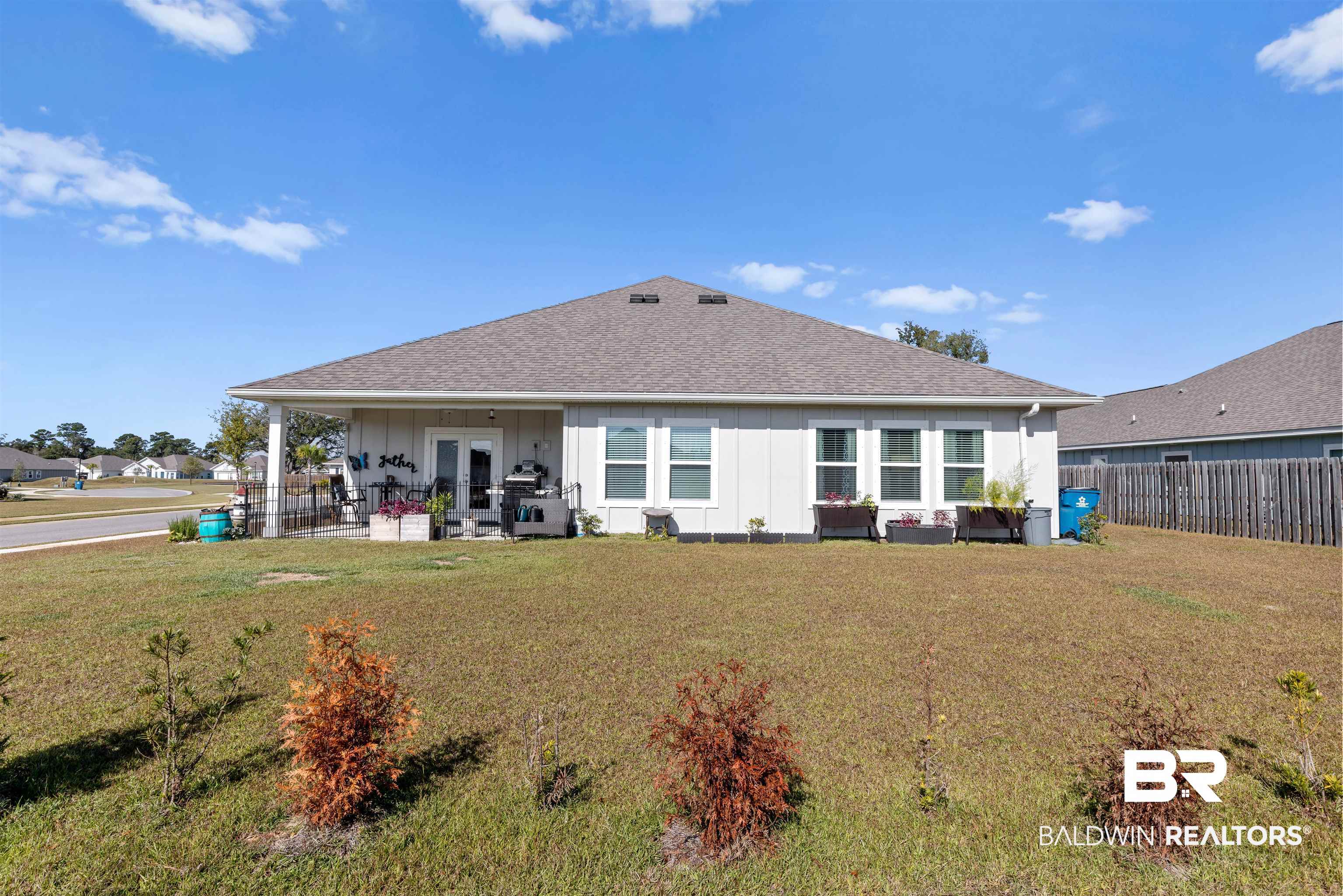 485 Shepard Street Gulf Shores, AL 36542 - Photo 5 of 53 Rear view of house with board and batten siding, roof with shingles, a patio, french doors, and a fenced backyard