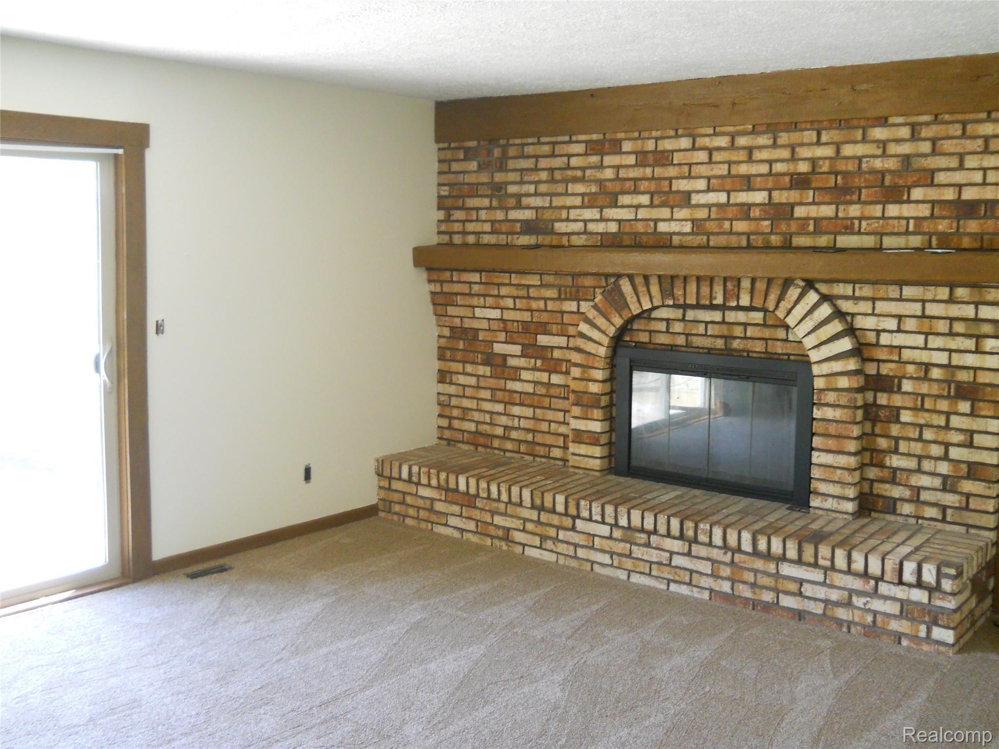 5929 Layton Road Fowlerville, MI 48836 - Photo 14 of 24 living room with huge brick natural fireplace & doorwall