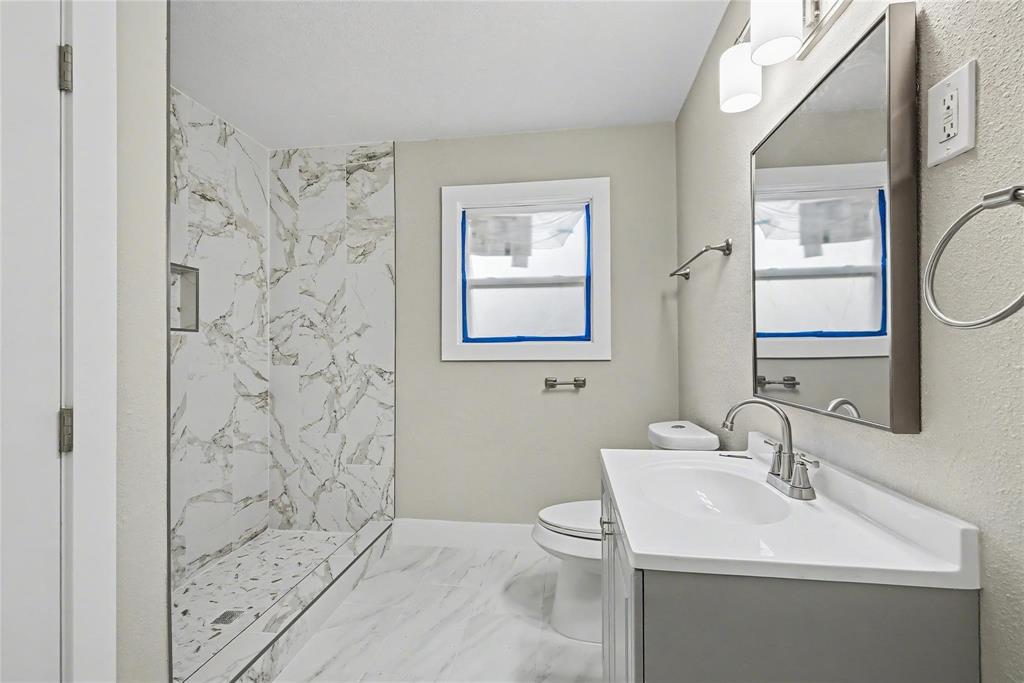 4220 Ramey Avenue Fort Worth, TX 76105 - Photo 11 of 24 a bathroom with a sink a toilet and shower