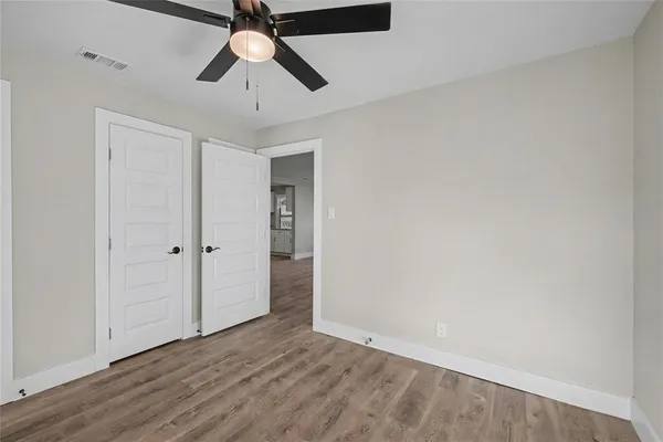 a view of empty room with wooden floor