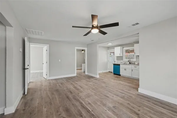 a view of empty room with wooden floor and window