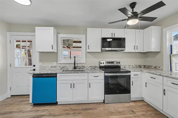a kitchen with stainless steel appliances granite countertop a stove a sink and a refrigerator