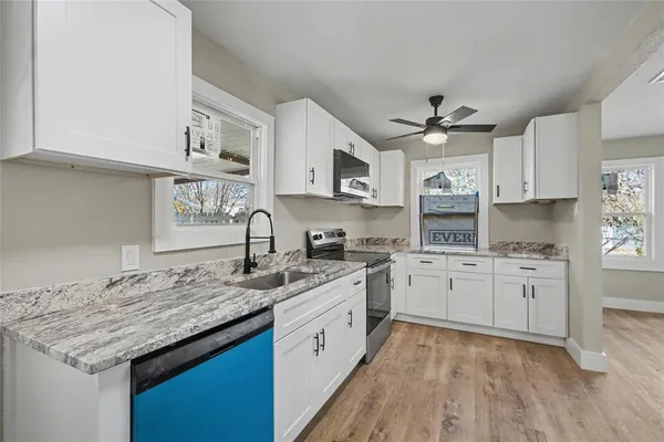 a kitchen with granite countertop cabinets stainless steel appliances a sink and a stove
