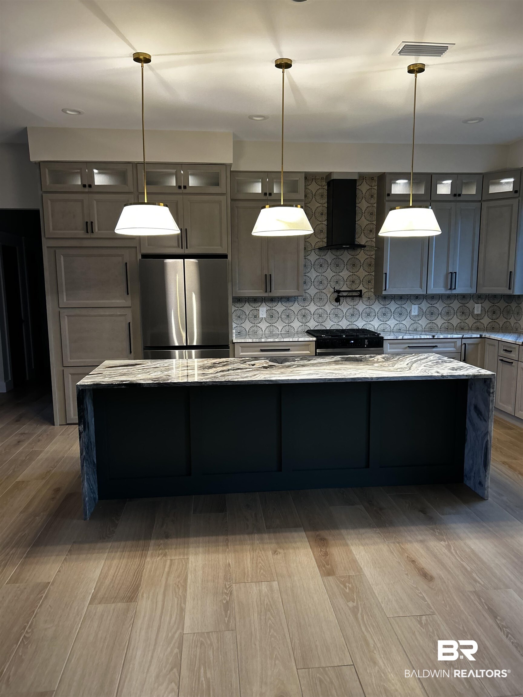 13066 Gopher Court Elberta, AL 36530 - Photo 29 of 38 Kitchen featuring a waterfall island with a stone countertop, light wood-finish flooring, and pendant lighting.
