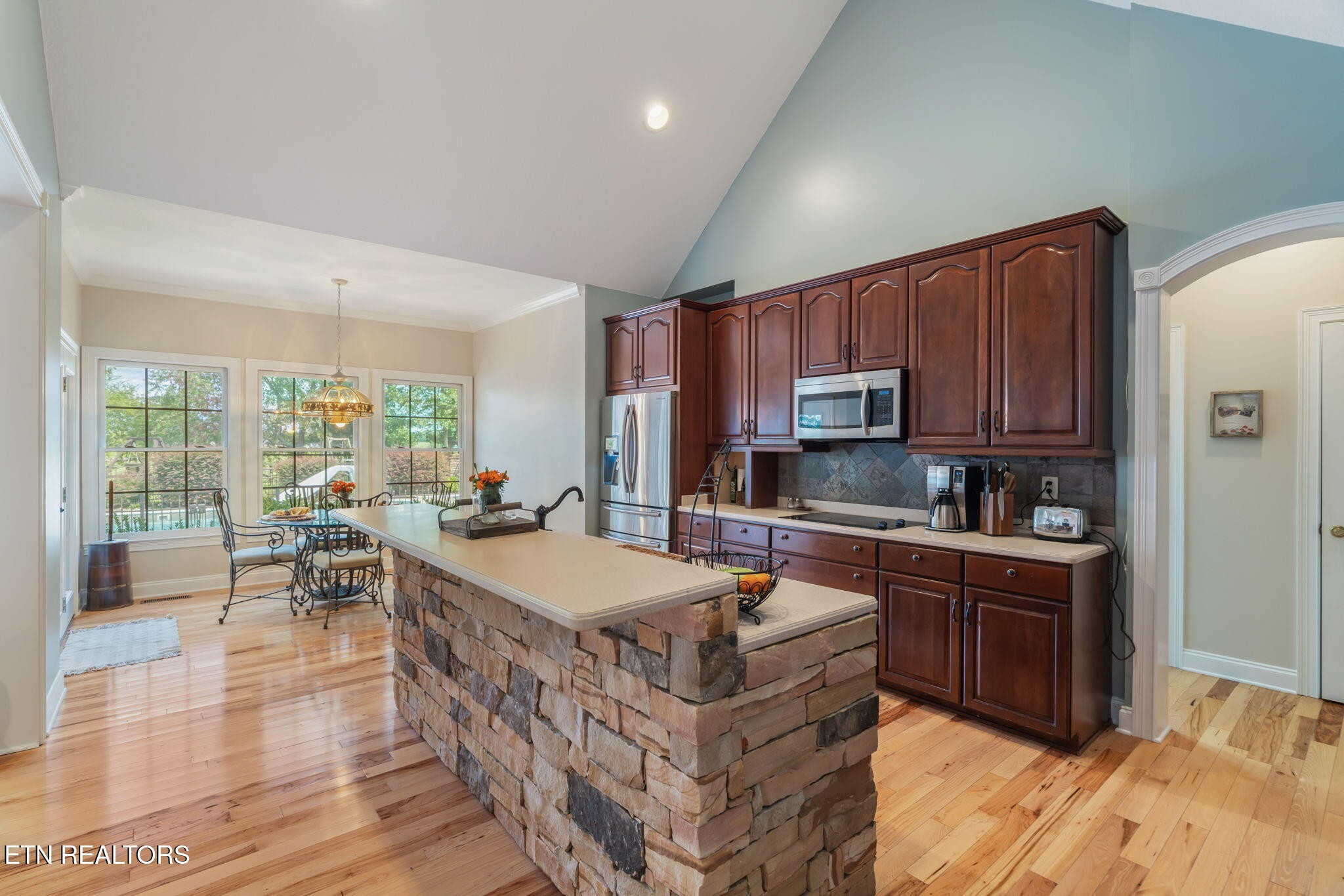 2572 Little Valley Road Loudon, TN 37774 - Photo 13 of 57 a large kitchen with stainless steel appliances granite countertop a stove top oven a sink dishwasher a dining table and chairs with wooden floor