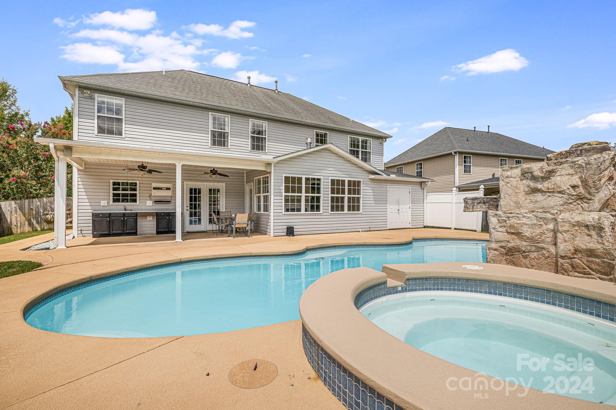 385 Wildbriar Road Fletcher, NC 28732 - Photo 36 of 42 a view of a white house with a large pool and a yard