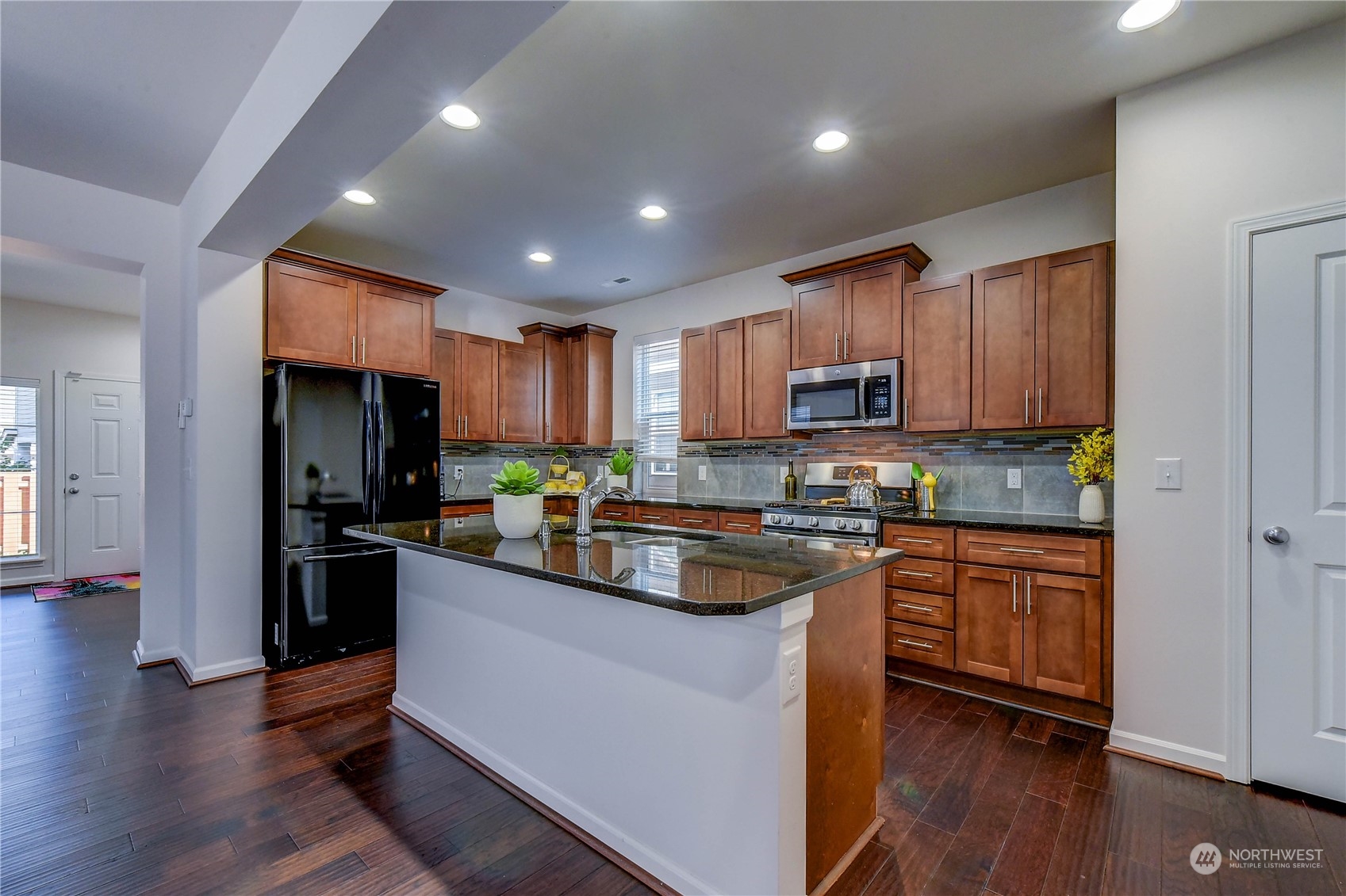 4501 30th Drive Southeast Everett, WA 98203 - Photo 7 of 29 a kitchen with kitchen island granite countertop wooden floors stainless steel appliances a sink and cabinets