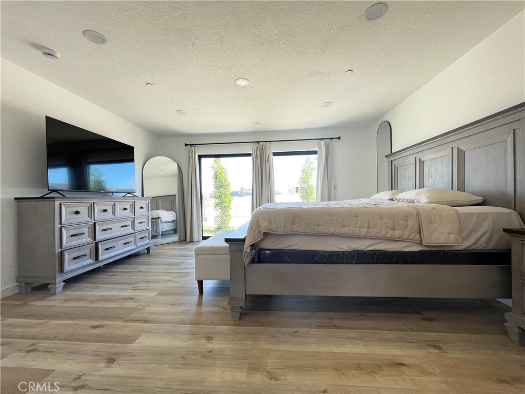 11375 4th Hesperia, CA 92345 - Photo 14 of 37 a bedroom with a large bed and a flat tv screen on dresser