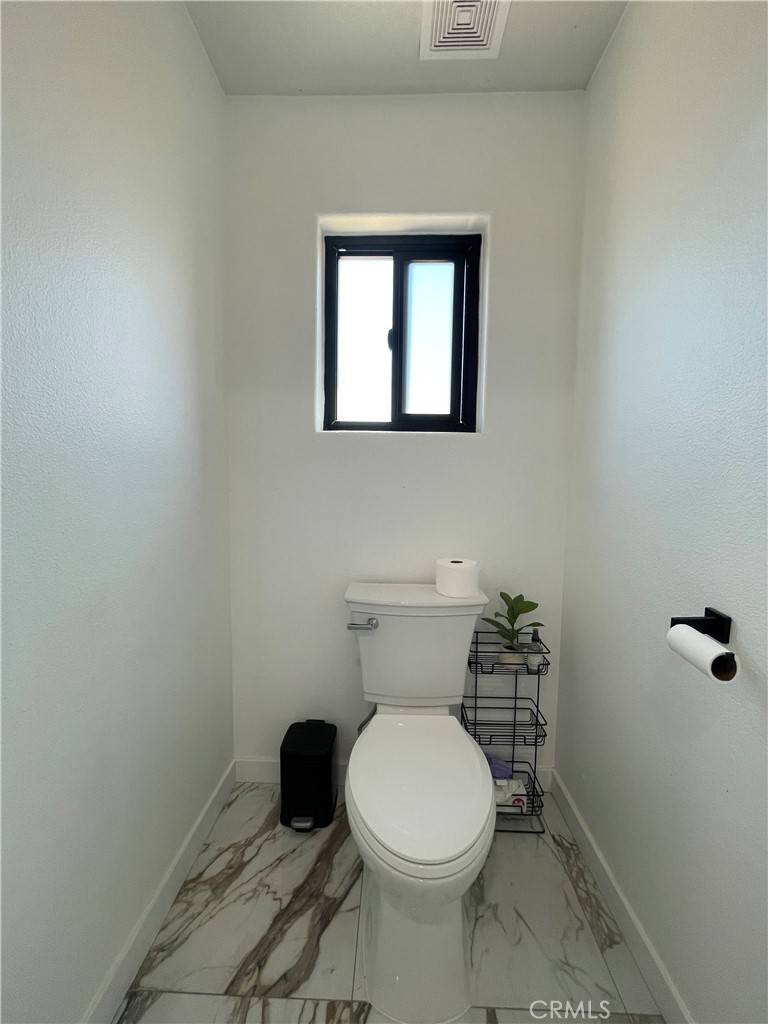 11375 4th Hesperia, CA 92345 - Photo 20 of 37 a white toilet sitting in a bathroom next to a sink