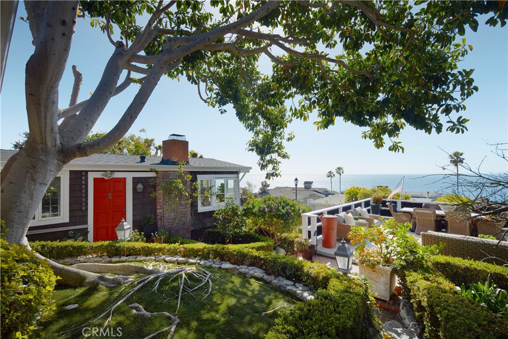 a view of a house with fountain plants and large tree