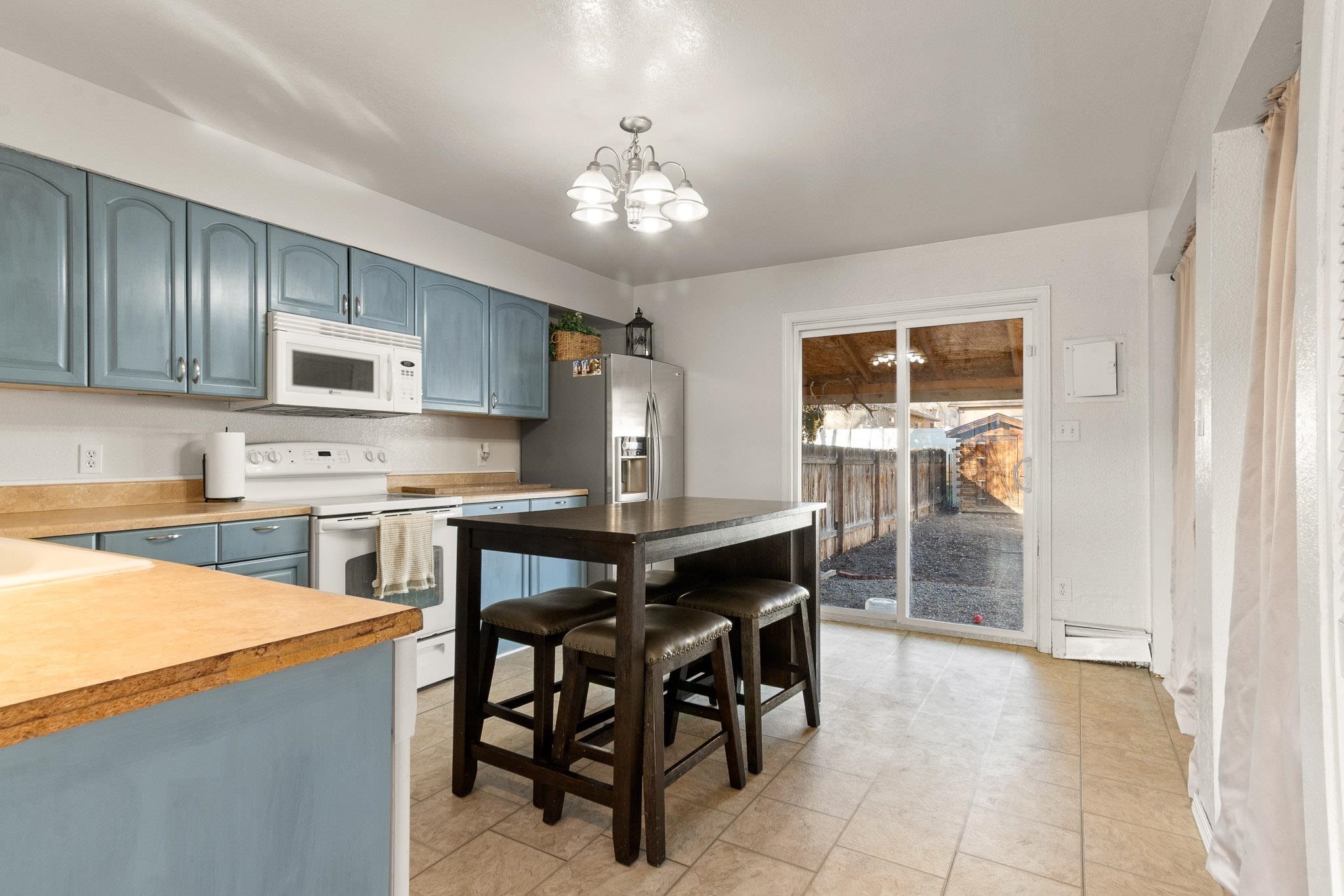 559 West Pabor Way, Unit 4 Fruita, CO 81521 - Photo 5 of 16 a kitchen with stainless steel appliances granite countertop a stove top oven a refrigerator a sink dishwasher a dining table and chairs with wooden floor