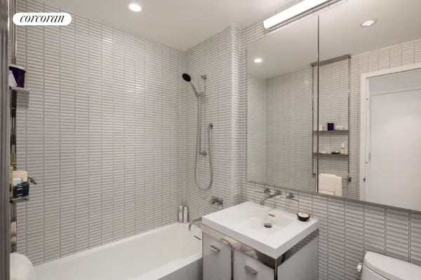 a bathroom with a sink mirror and shower