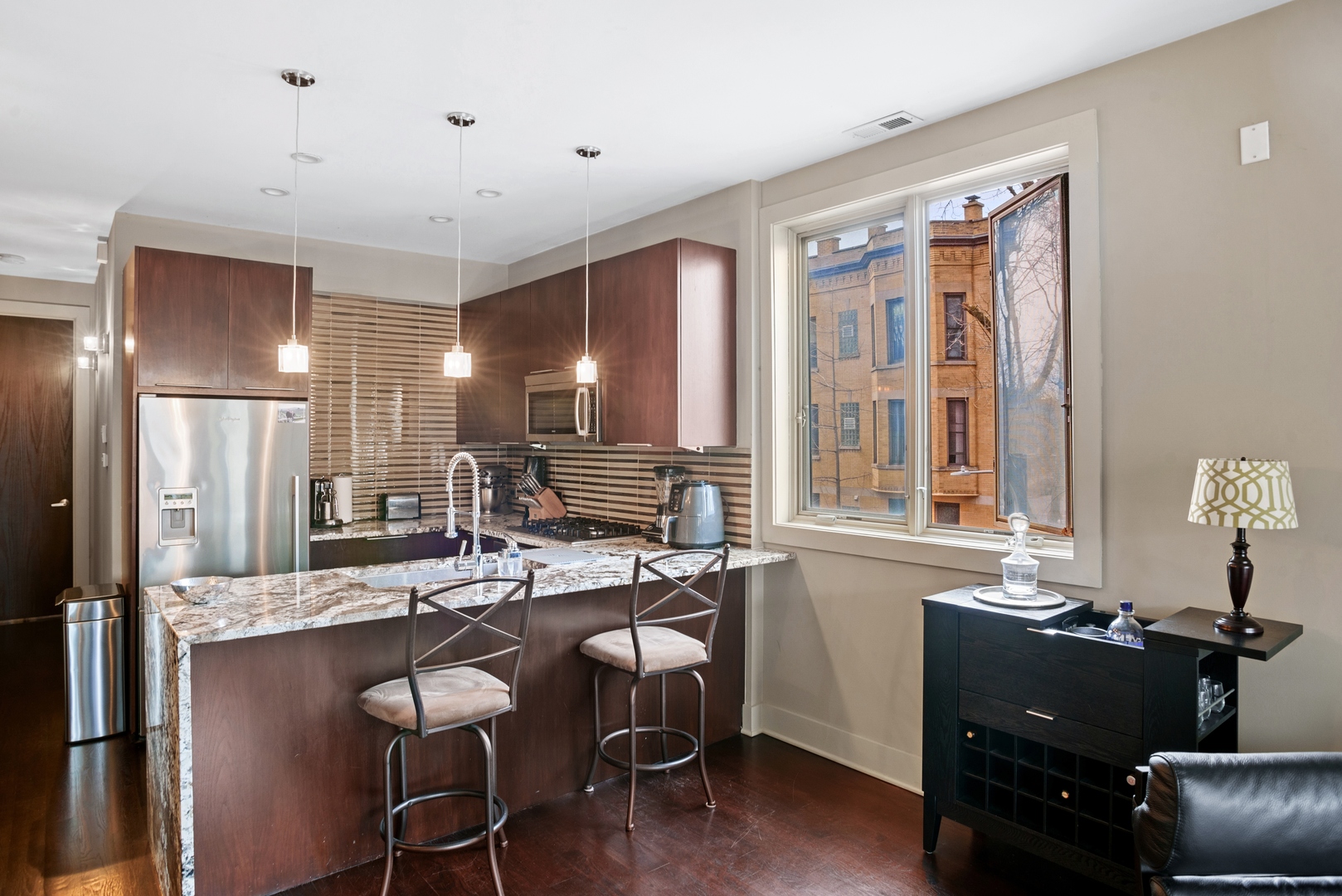 1257 West Addison Street, Unit 2 Chicago, IL 60613 - Photo 4 of 11 a kitchen with a table chairs appliances and cabinets