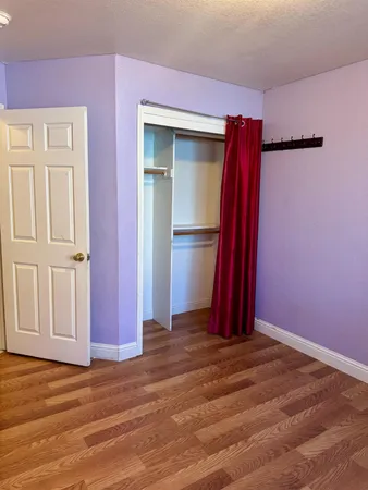 a view of a room with wooden floor and a window