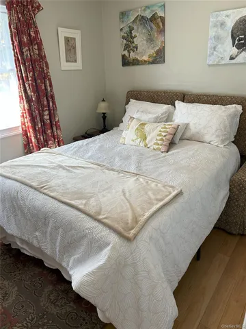 a bedroom with a bed and painting on the wall