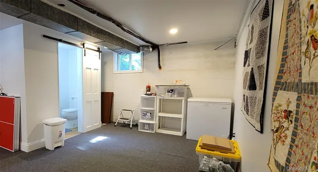 a view of a storage & utility room with closet dryer and window
