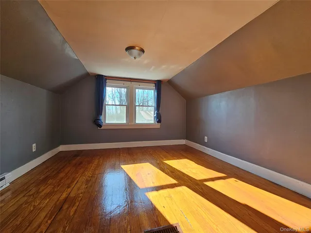 a view of a room with wooden floor and a window