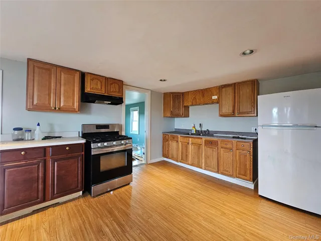 a kitchen with stainless steel appliances granite countertop a stove a sink and a refrigerator