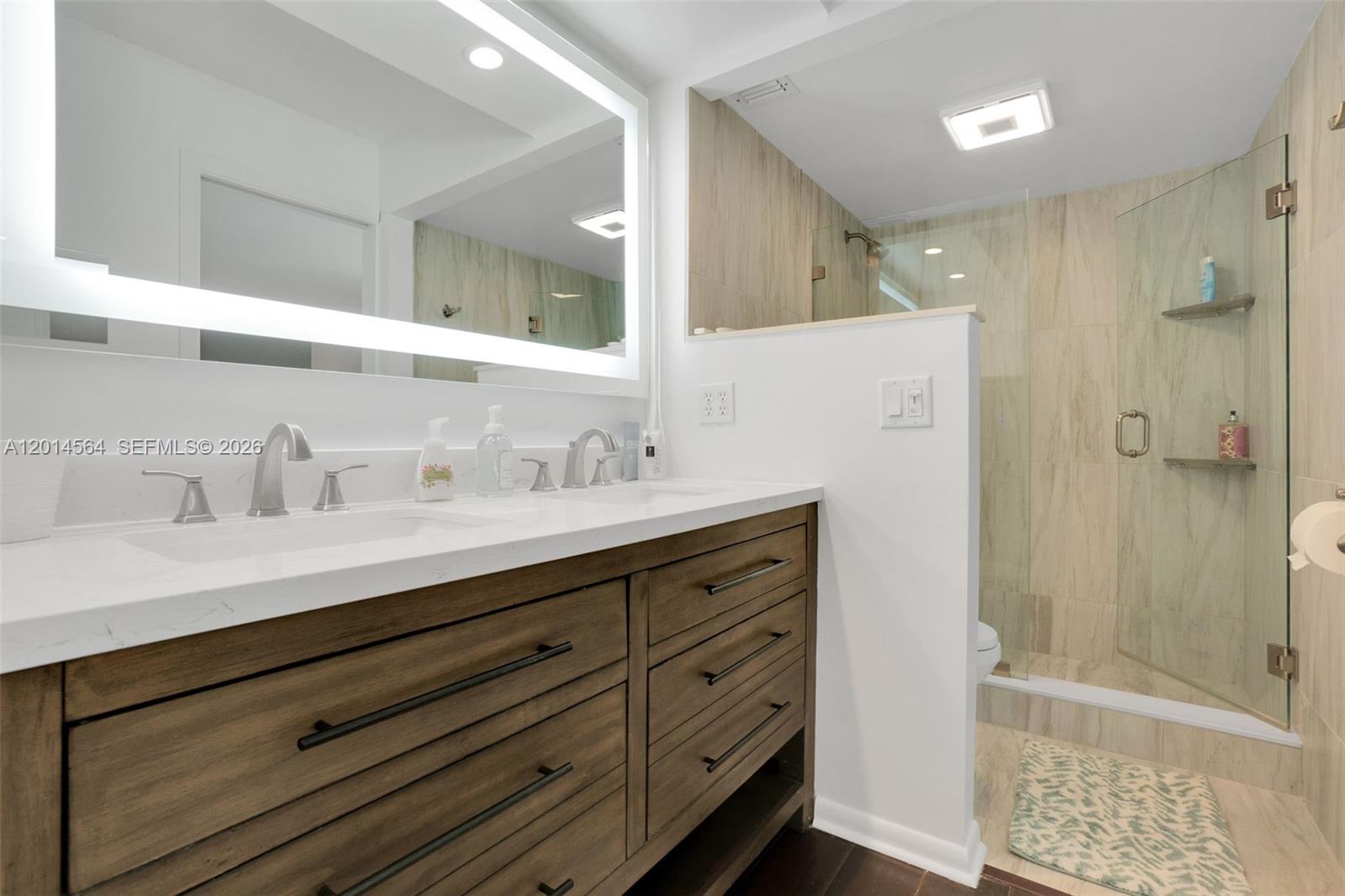 500 Egret Circle, Unit 8403 Delray Beach, FL 33444 - Photo 15 of 32 a bathroom with a shower sink and mirror