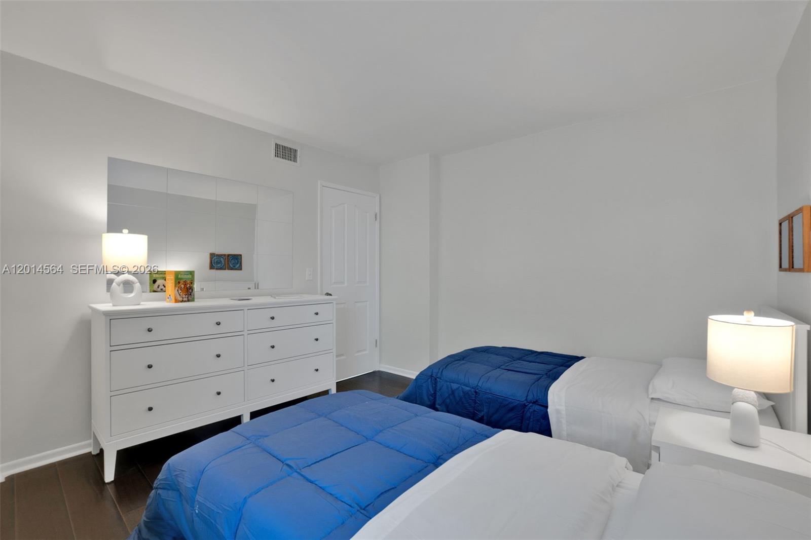500 Egret Circle, Unit 8403 Delray Beach, FL 33444 - Photo 19 of 32 a bedroom with two beds and a lamp on dresser