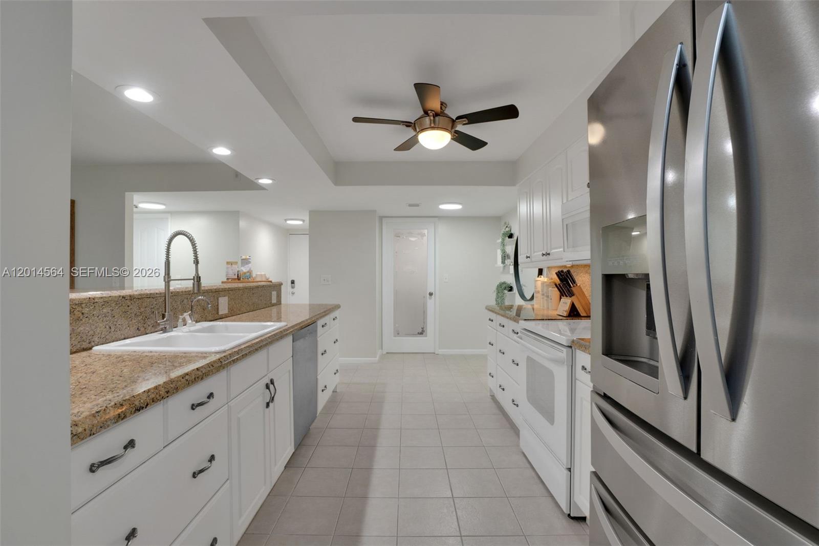 500 Egret Circle, Unit 8403 Delray Beach, FL 33444 - Photo 3 of 32 a large kitchen with stainless steel appliances kitchen island granite countertop a large counter top a sink and a refrigerator
