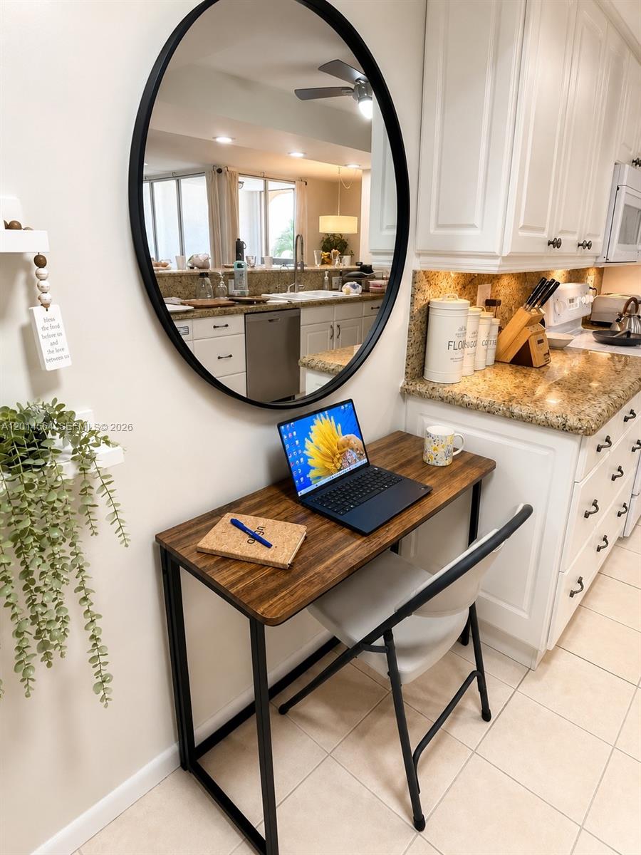 500 Egret Circle, Unit 8403 Delray Beach, FL 33444 - Photo 9 of 32 a view of a kitchen with kitchen island a stove a chimney a dining table and chairs