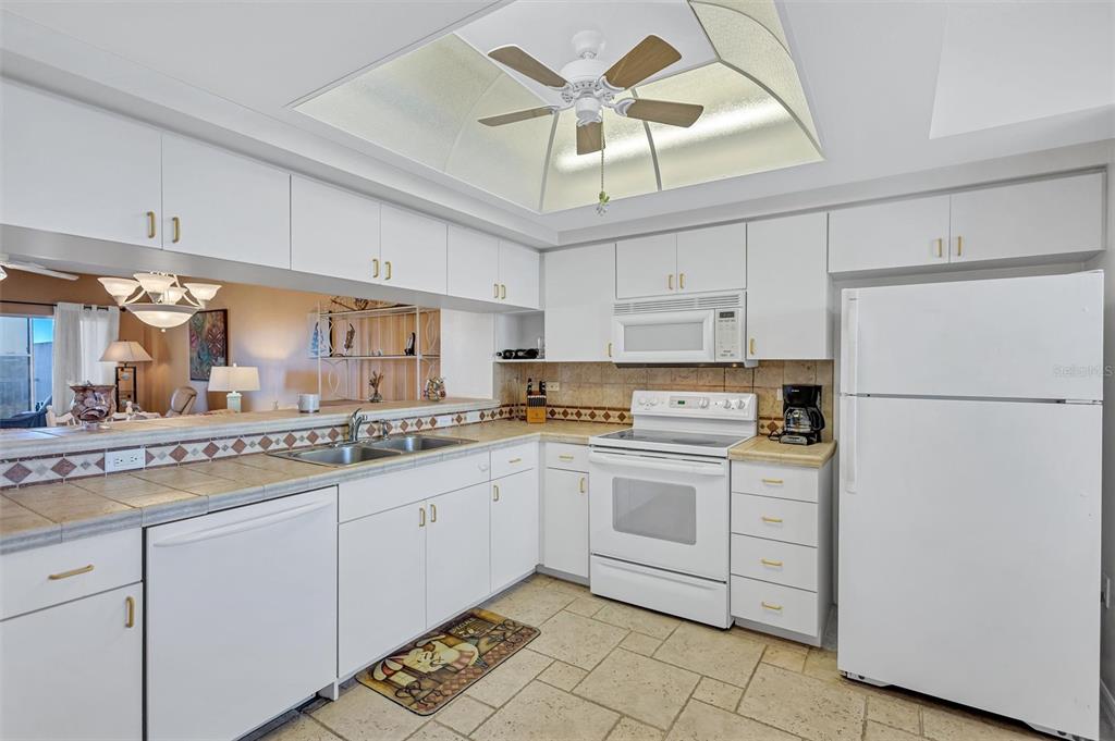 6475 Shoreline Drive, Unit 5102 St. Petersburg, FL 33708 - Photo 11 of 39 a kitchen with white cabinets and white appliances
