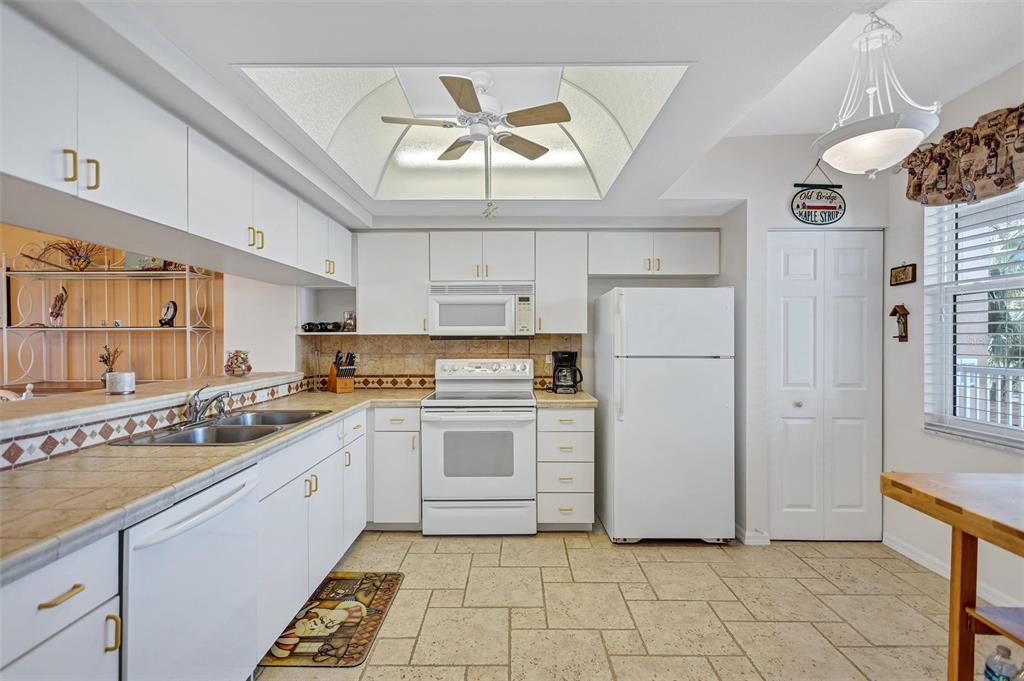 6475 Shoreline Drive, Unit 5102 St. Petersburg, FL 33708 - Photo 12 of 39 a kitchen with a stove a sink and a refrigerator