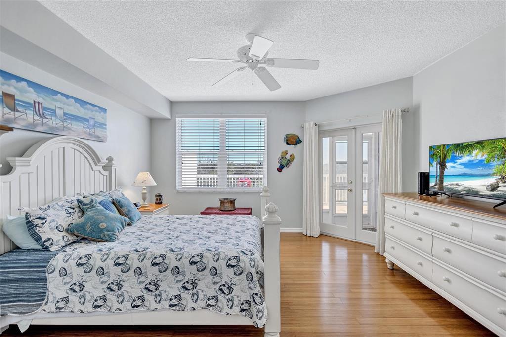 6475 Shoreline Drive, Unit 5102 St. Petersburg, FL 33708 - Photo 17 of 39 a bedroom with a large bed and a flat tv screen on dresser