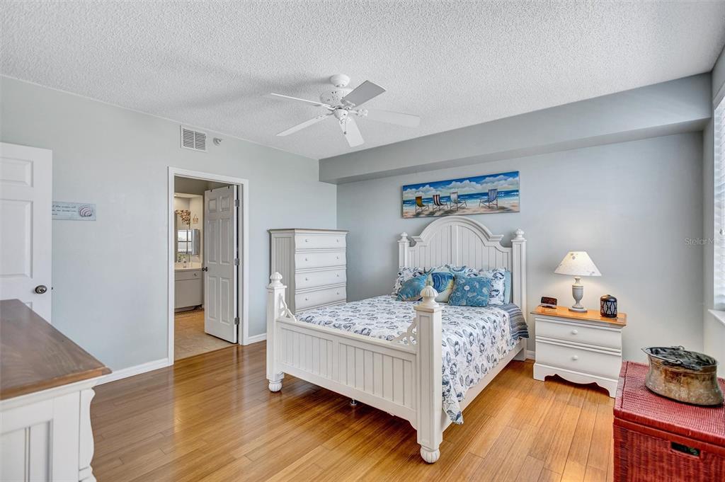 6475 Shoreline Drive, Unit 5102 St. Petersburg, FL 33708 - Photo 18 of 39 a bedroom with a bed and wooden floor