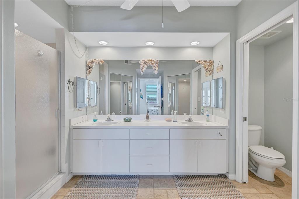 6475 Shoreline Drive, Unit 5102 St. Petersburg, FL 33708 - Photo 21 of 39 a bathroom with a double vanity sink a toilet and a shower