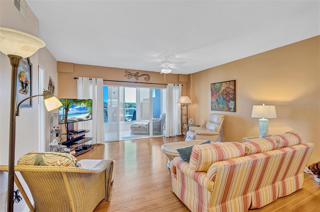 6475 Shoreline Drive, Unit 5102 St. Petersburg, FL 33708 - Photo 9 of 39 a living room with furniture a large window and a wooden floor